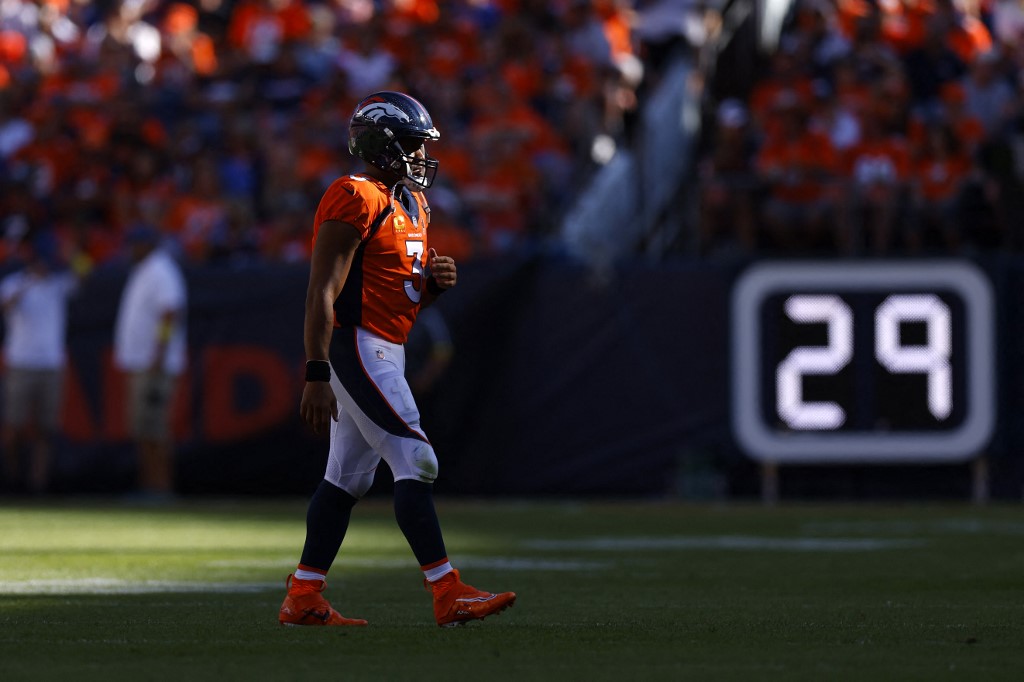 Russell Wilson of the Denver Broncos walks off the field as we share our favorite Commanders vs. Broncos pick.