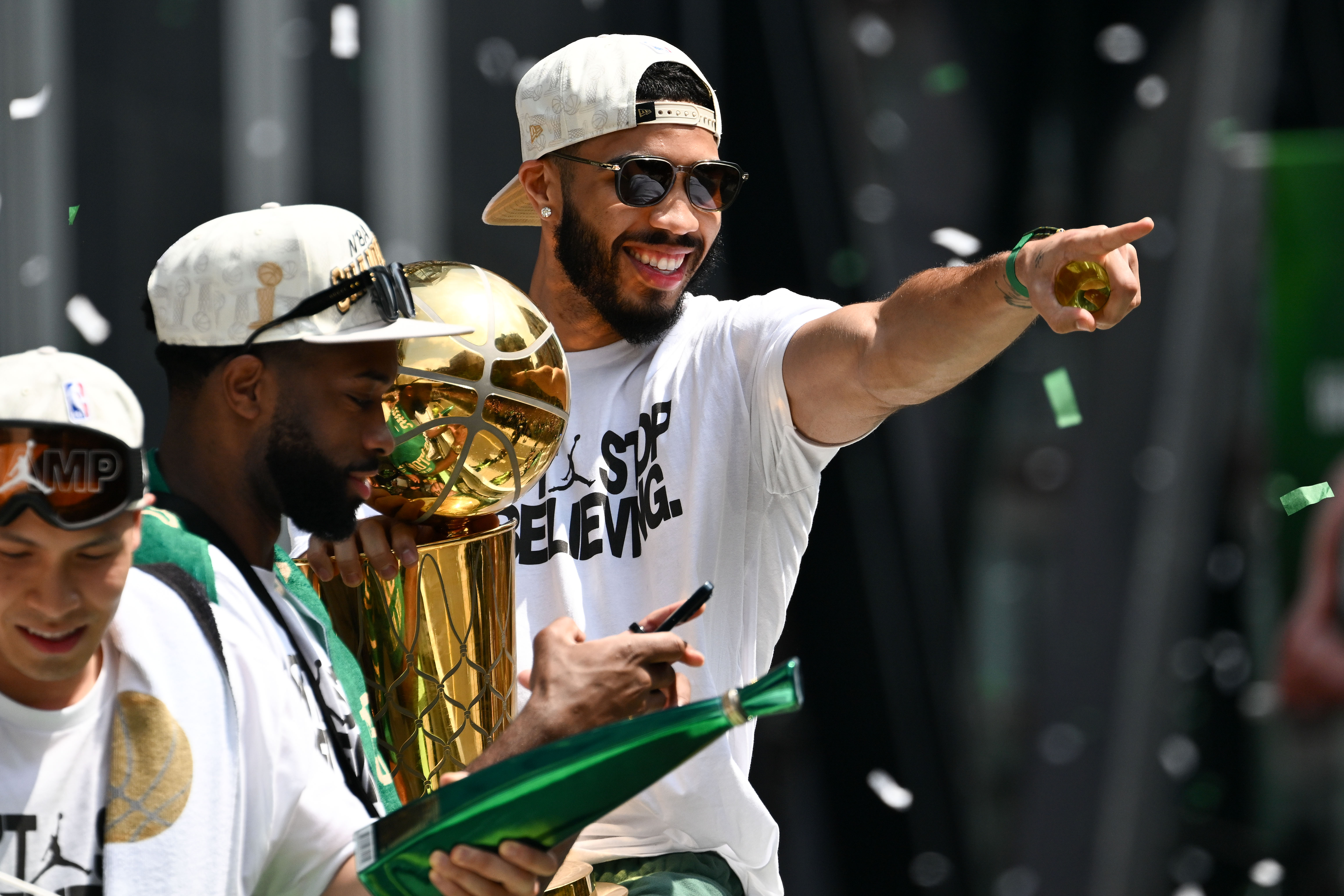 Boston Celtics forward Jayson Tatum points to the crowd with the Larry O'Brien Championship Trophy during the 2024 NBA Championship parade in Boston as we look at SimpleBet and it's successful NBA season.