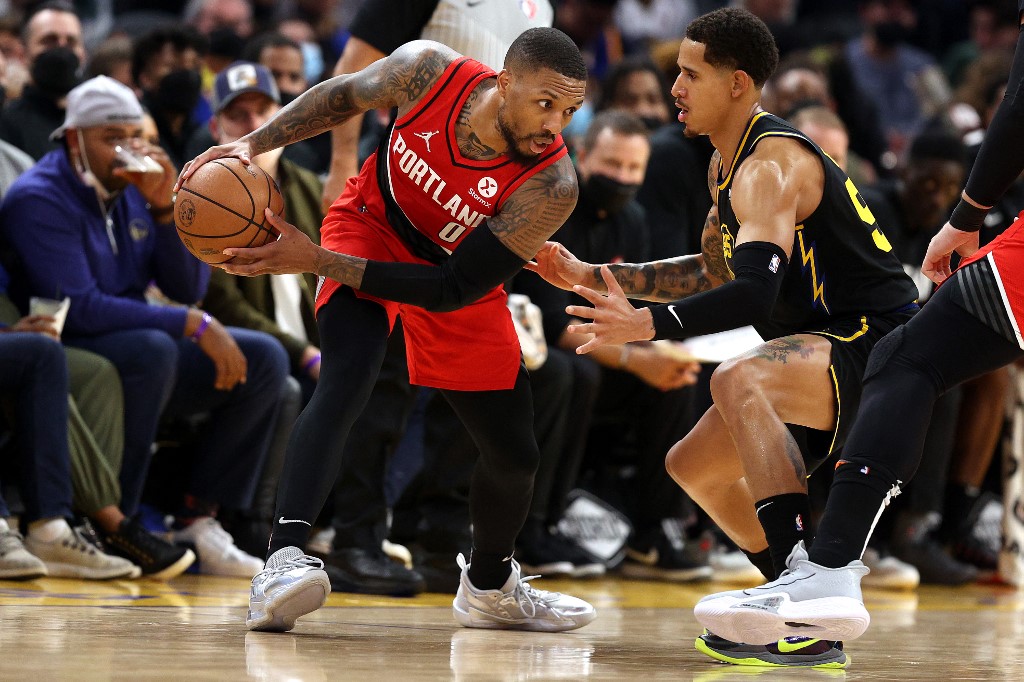 Damian Lillard of the Portland Trail Blazers handles the ball against Juan Toscano-Anderson of the Golden State Warriors.