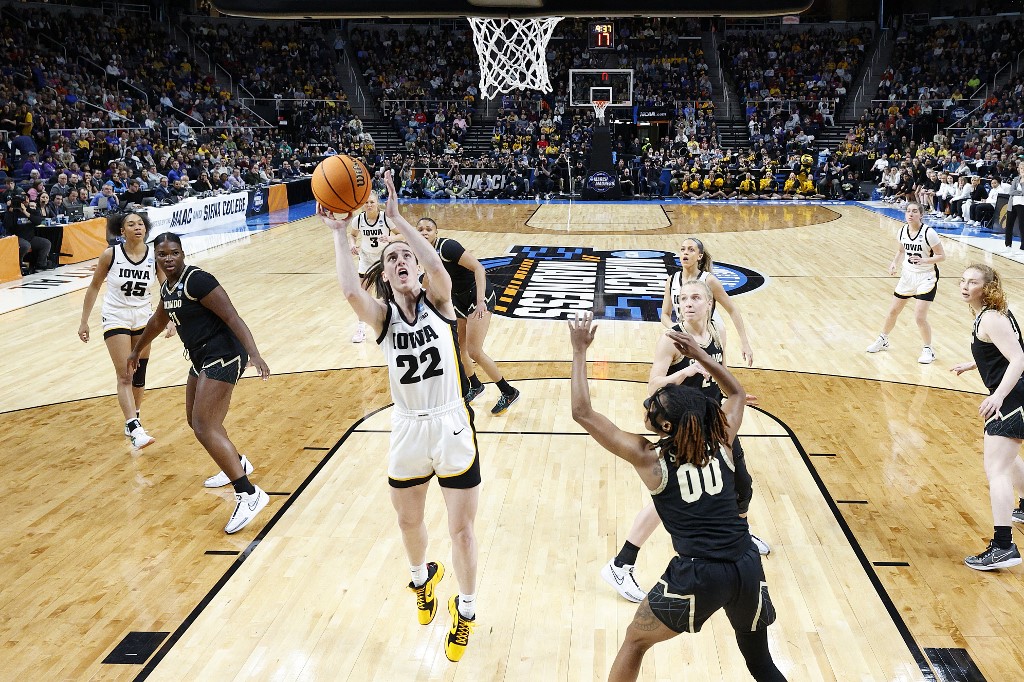 Caitlin Clark of the Iowa Hawkeyes shoots against Jaylyn Sherrod of the Colorado Buffaloes during the Sweet 16 round of the NCAA Women's Basketball Tournament. We expect a high-scoring game in our LSU vs. Iowa prediction & odds.