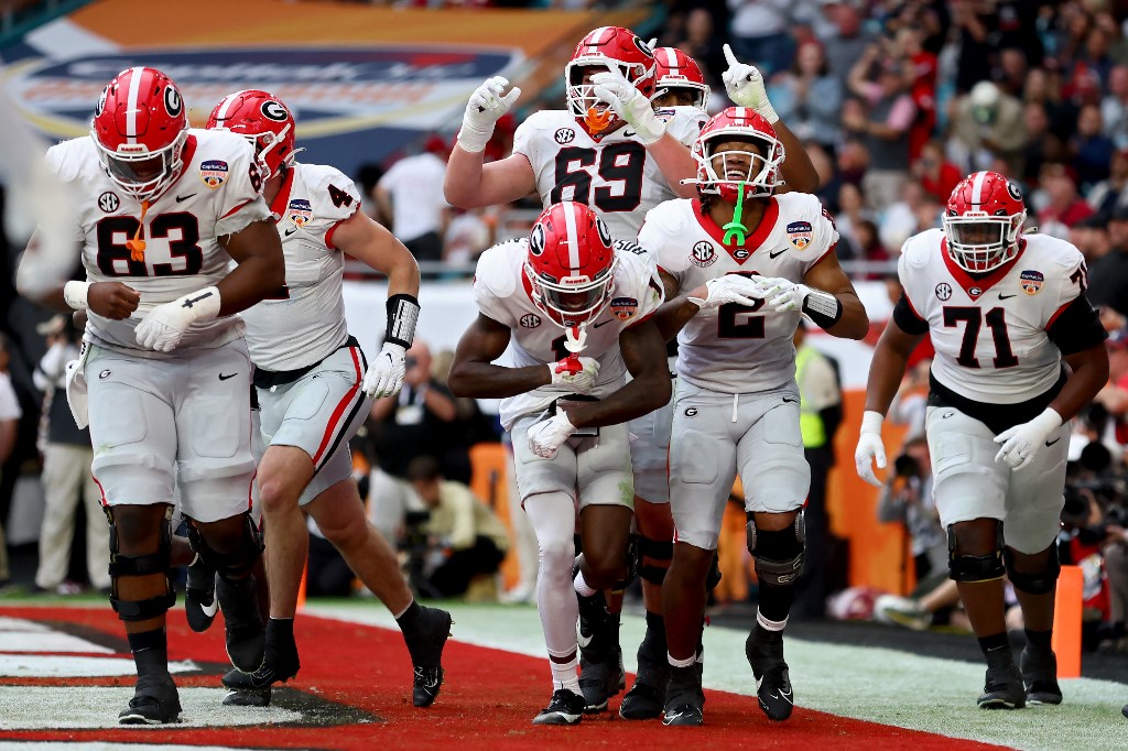 Kendall Milton of the Georgia Bulldogs celebrates with teammates after scoring a touchdown against the Florida State Seminoles during the Capital One Orange Bowl. Georgia leads the way for the College Football Projected Win Totals.