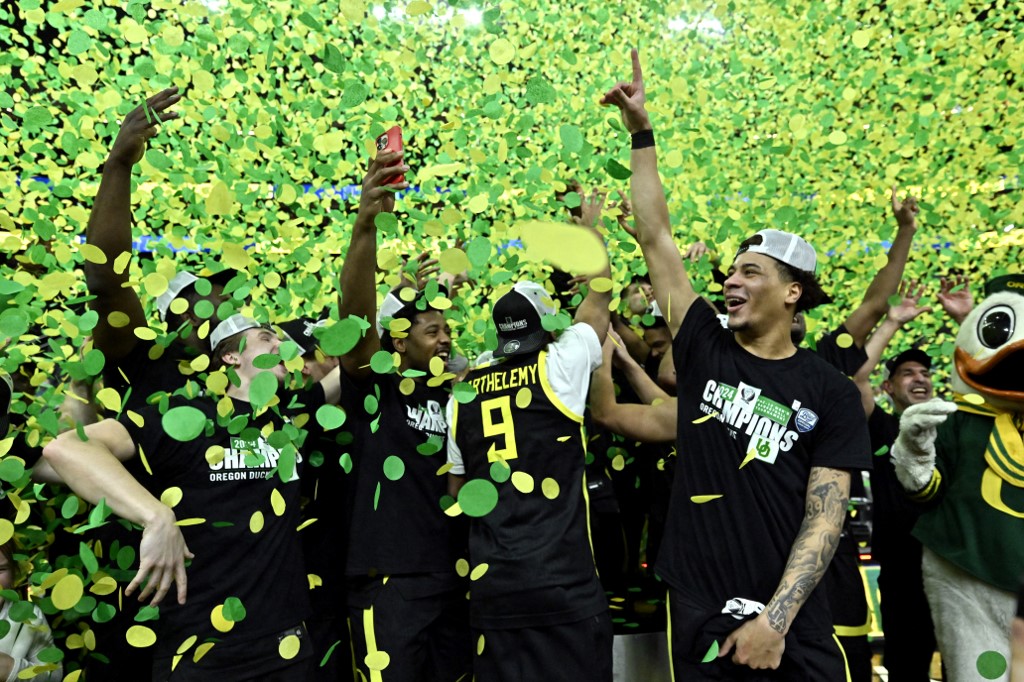 The Oregon Ducks celebrate their victory over the Colorado Buffaloes after the championship game in the Pac-12 basketball tournament.