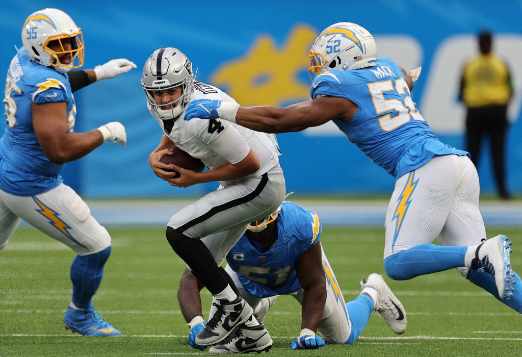 Aidan O'Connell #4 of the Las Vegas Raiders is pressured by Sebastian Joseph-Day #51 and Khalil Mack #52 of the Los Angeles Chargers as we make our Chargers vs. Raiders player prop picks and predictions for Thursday Night Football.