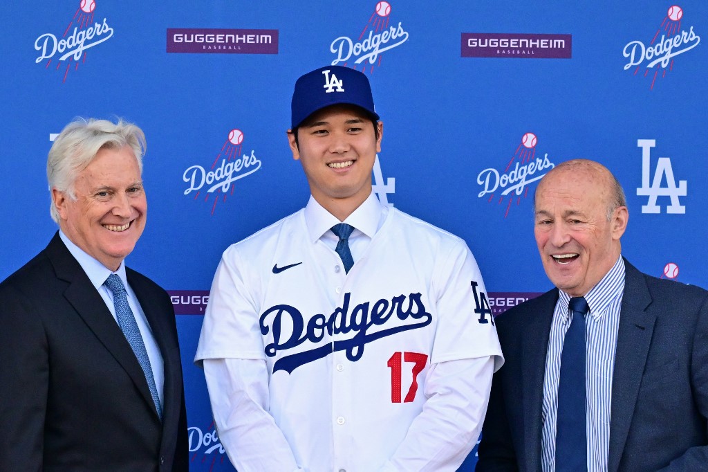 Shohei Ohtani poses with Mark Walter, owner of the Los Angeles Dodgers, and Andrew Friedman, president of baseball operations, during his introductory press conference, and we're looking at the win totals of every MLB team based on the best MLB odds.