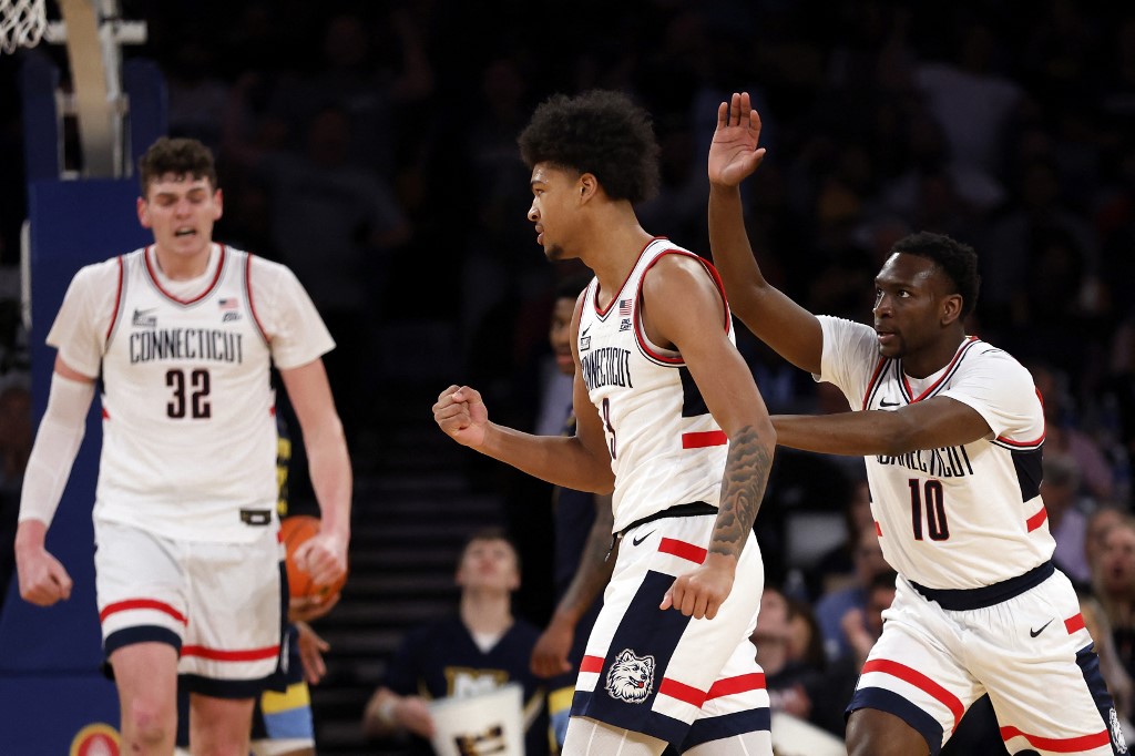 Jaylin Stewart #3, Hassan Diarra #10 and Donovan Clingan #32 of the Connecticut Huskies react as we look at which teams have a chance to win March Madness ahead of the 2024 NCAA Tournament.