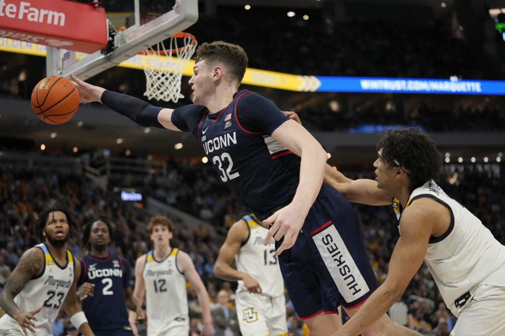 Donovan Clingan of the UConn Huskies goes for a rebound against Stevie Mitchell of the Marquette Golden Eagles. Patrick McDermott/Getty Images via AFP. Clingan is the focus of our Marquette vs. UConn prediction in the Big East Tournament.