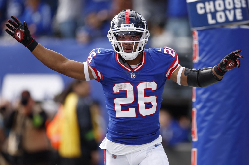 Saquon Barkley of the New York Giants celebrates after scoring a touchdown against the Washington Commanders as we look at the New York sports betting revenue report for January 2024.