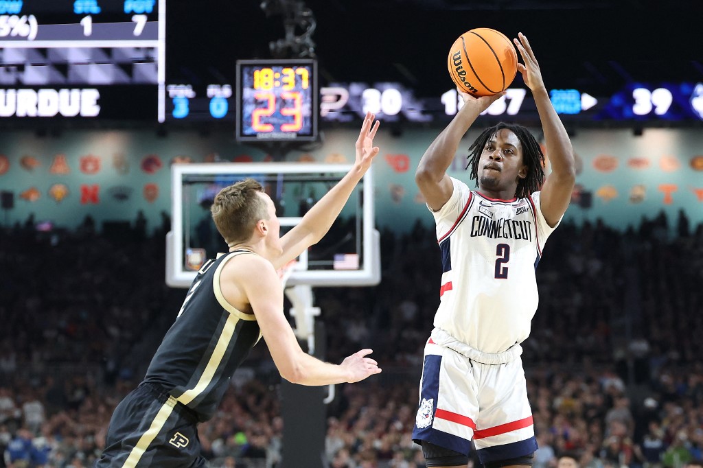 Tristen Newton of the UConn Huskies attempts a shot while being guarded by Fletcher Loyer of the Purdue Boilermakers during the NCAA Men's Basketball Tournament National Championship game. Newton was +700 by the March Madness MVP odds 2024.