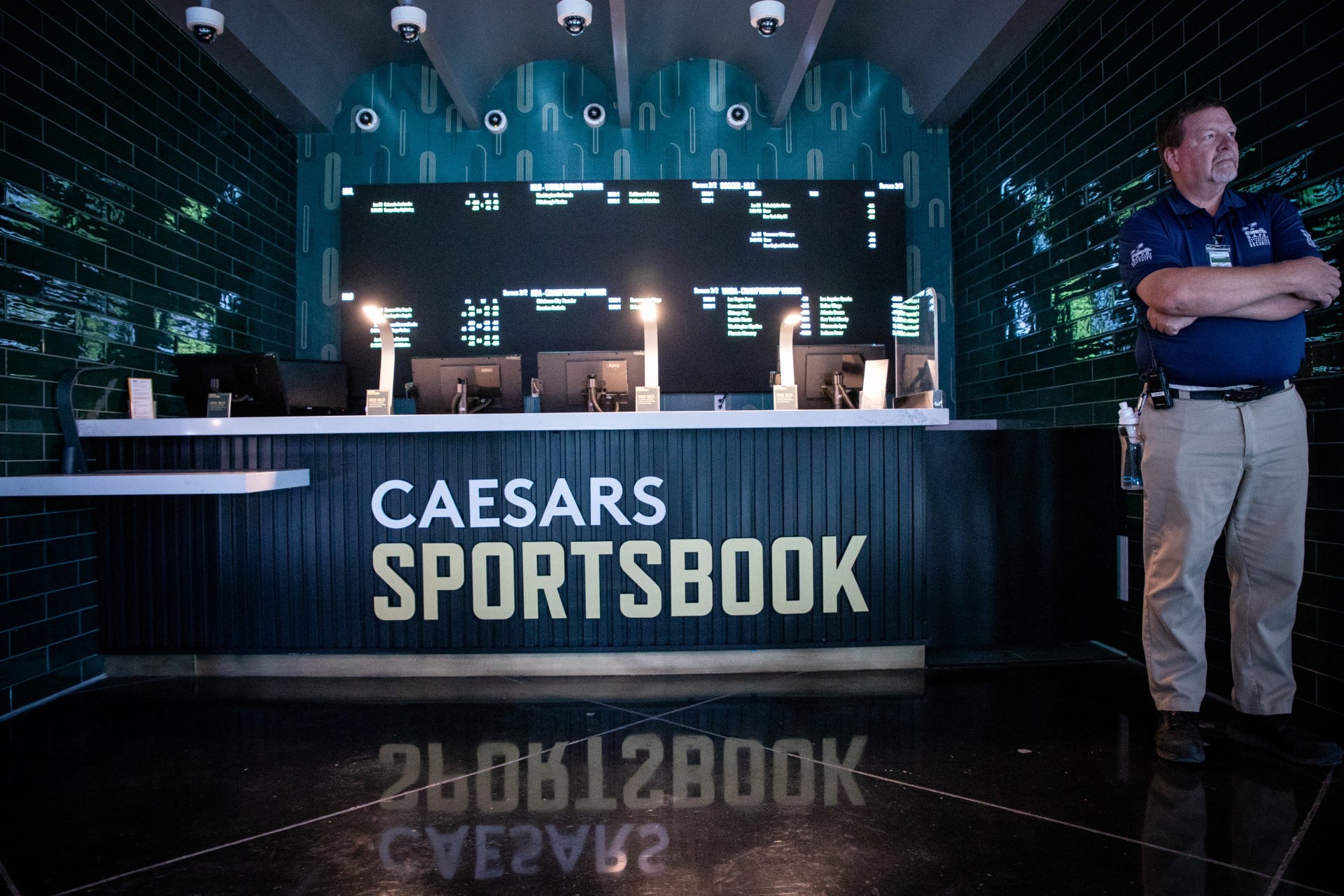 A security guard stands in front of one of the betting windows on the second floor of the Caesars Underscoreg at Chase Field in Phoenix.