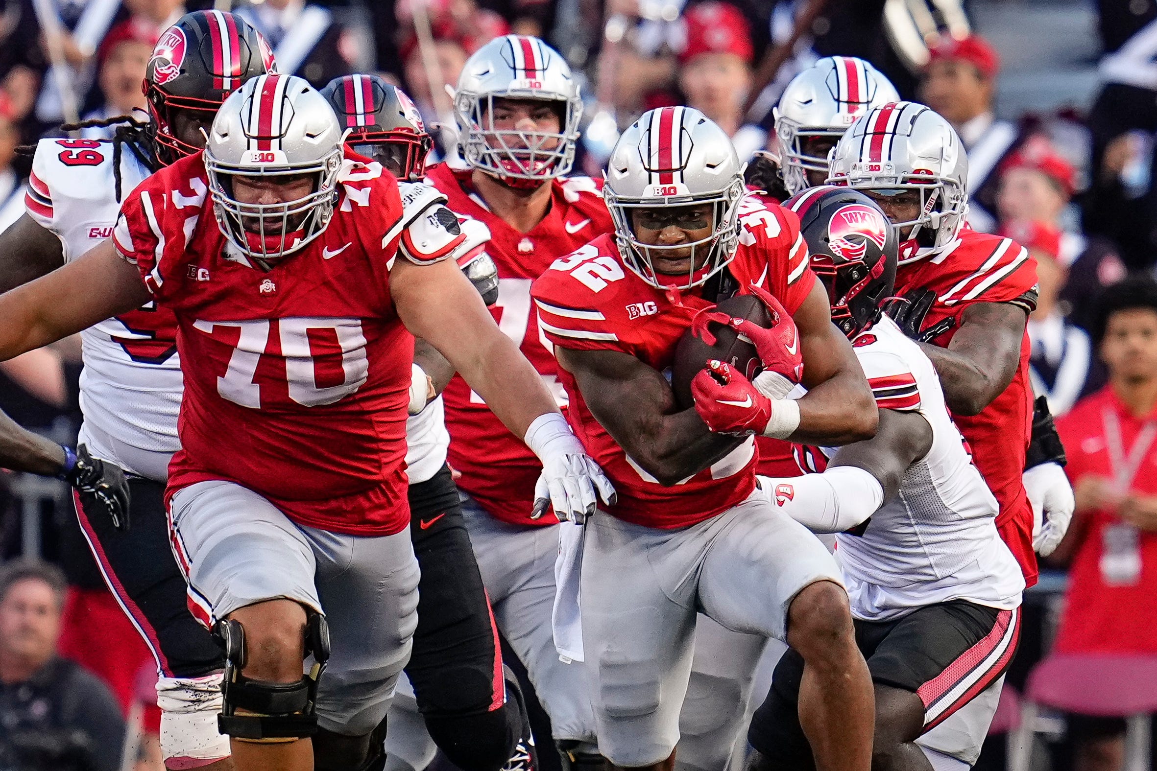 Ohio State Buckeyes running back TreVeyon Henderson gets a block from offensive lineman Josh Fryar during the second half against the Western Kentucky Hilltoppers. The Buckeyes lead the Big Ten Championship Odds.