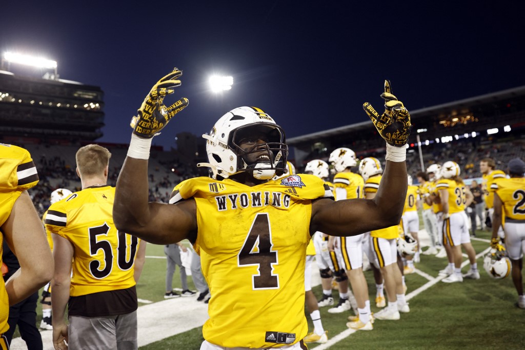 Running back Harrison Waylee of the Wyoming Cowboys celebrates as we look at Fanatic Underscoregs launch in the state.