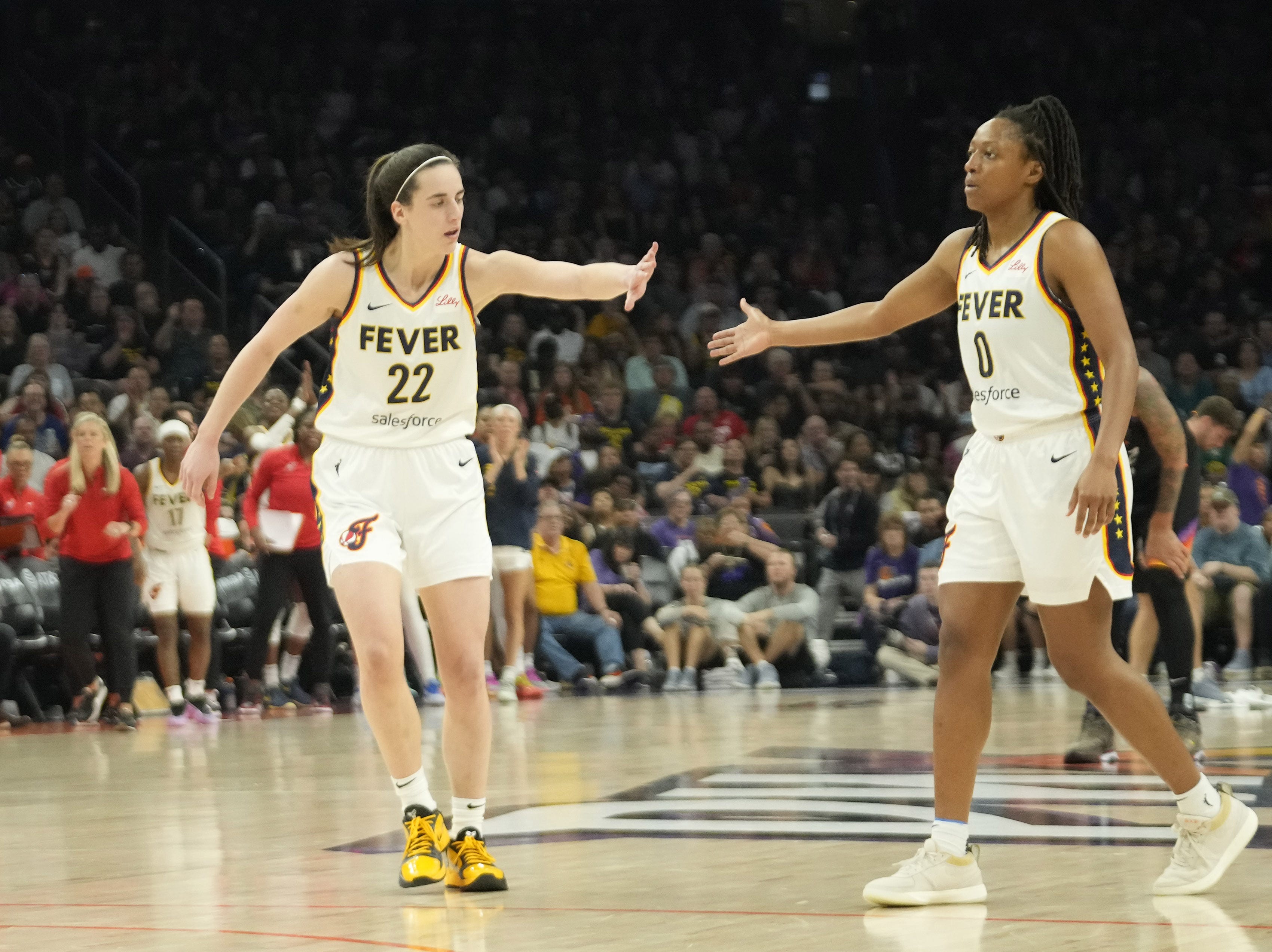 Indiana Fever guard Caitlin Clark (22) slaps hands with guard Kelsey Mitchell (0) as we offer our best Fever vs. Aces prediction and expert picks for Tuesday's WNBA matchup at T-Mobile Arena in Las Vegas.