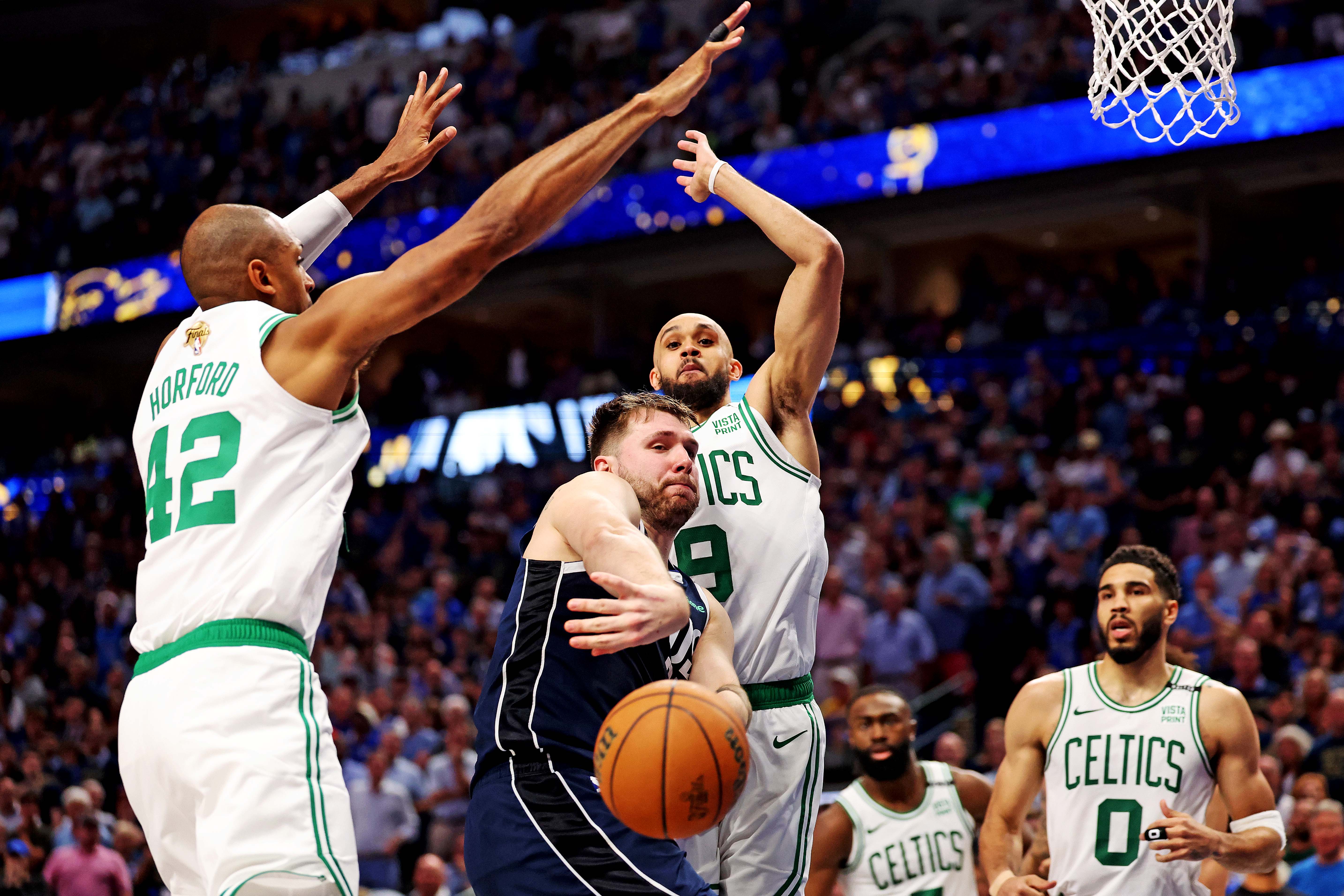 Dallas Mavericks guard Luka Doncic passes the ball against Boston Celtics center Al Horford and guard Derrick White during the fourth quarter of Game 3 of the 2024 NBA Finals. We look at both Doncic and Horford in our Celtics vs. Mavericks Parlay.