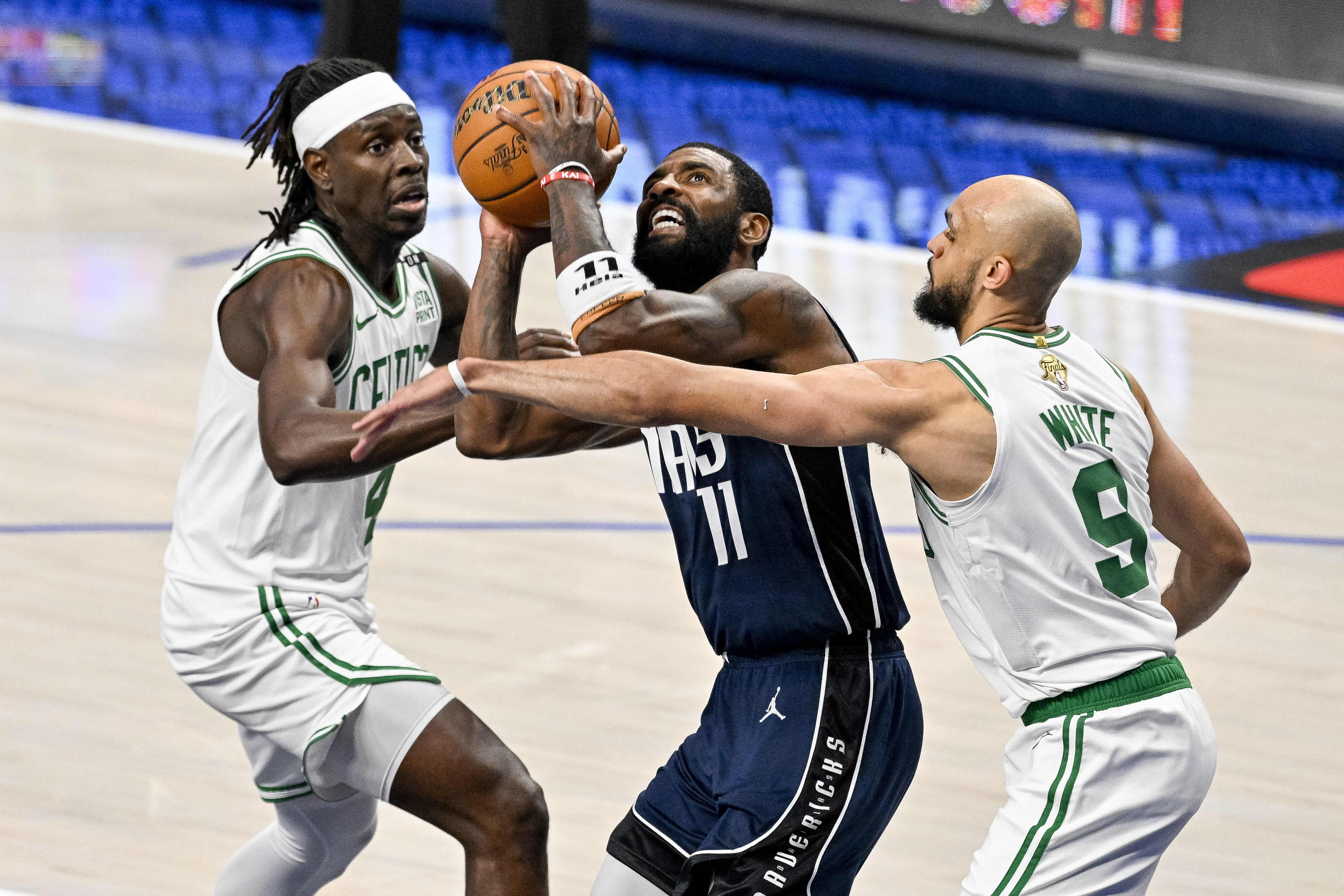 Dallas Mavericks guard Kyrie Irving drives to the basket between Boston Celtics guard Jrue Holiday and guard Derrick White during Game 4 of the 2024 NBA Finals. We're backing White in our Mavericks vs. Celtics Parlay.