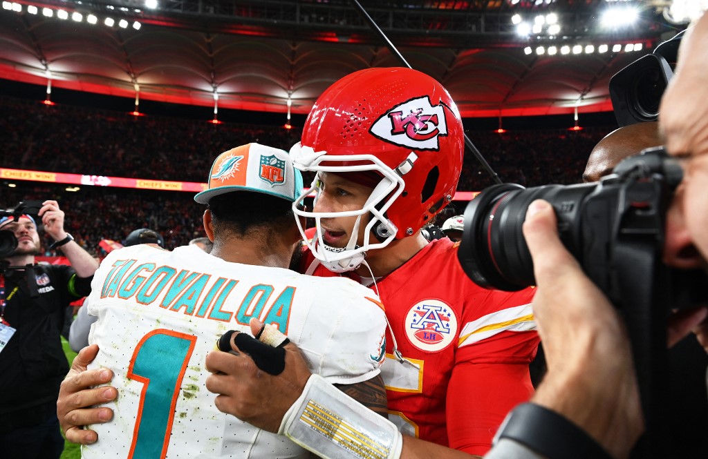 Quarterback Patrick Mahomes (M) of the Chiefs and quarterback Tua Tagovailoa (l) of the Dolphins hug as we look at the best NFL Wild Card Weekend odds