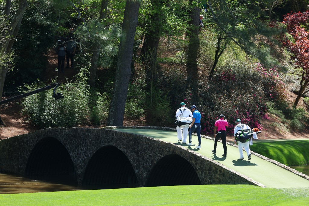 Joaquin Niemann of Chile and Tiger Woods walk across the Hogan Bridge as we look at our best Masters odds boosts