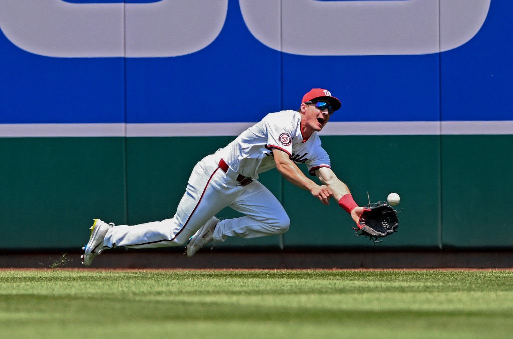 Jacob Young of the Washington Nationals catches a fly ball as we look at the sports betting financials for FanDuel's first month of operation in the DC sports betting scene.