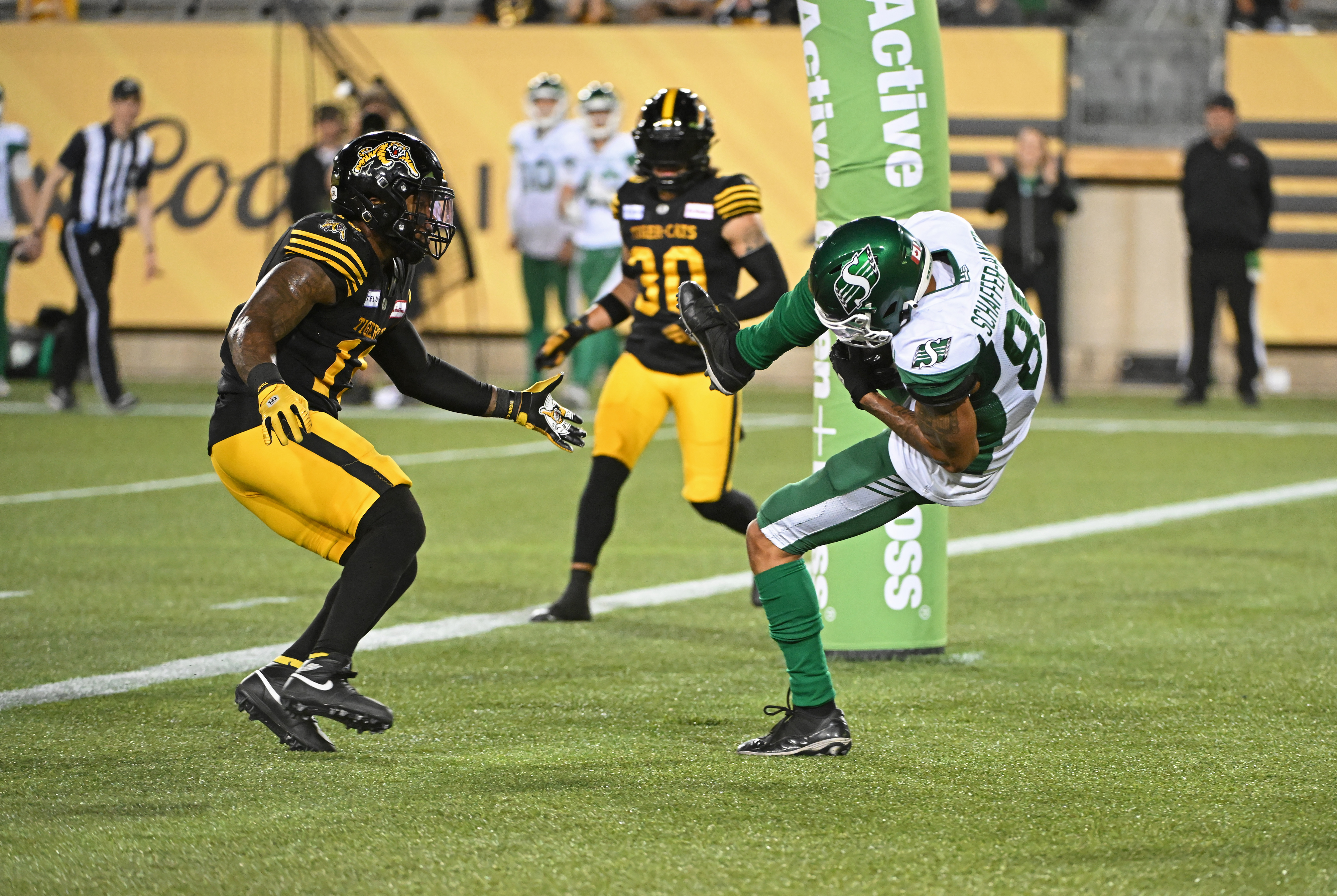 Saskatchewan Roughriders wide receiver Kian Schaffer-Baker catches a touchdown pass in front of Hamilton Tiger-Cats linebacker Kyle Wilson at Tim Hortons Field. We expect another high-scoring game in our Tiger-Cats vs. Roughriders Prediction.