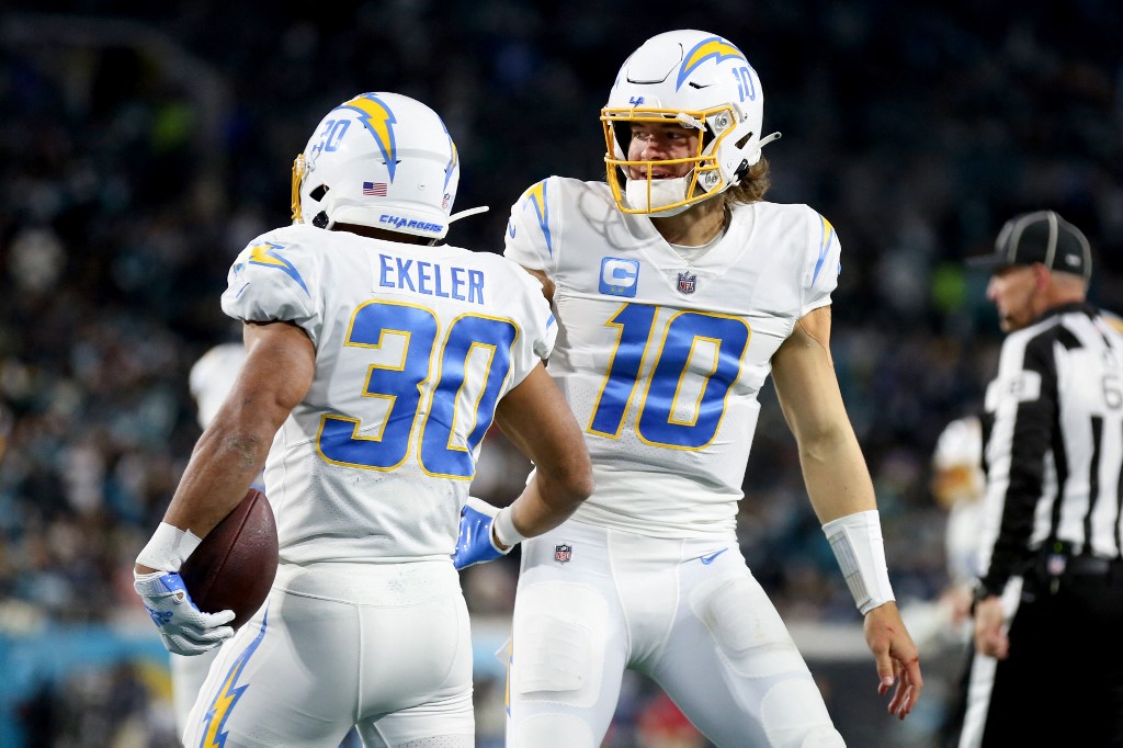 Austin Ekeler of the Los Angeles Chargers celebrates with teammate Justin Herbert after rushes for a touchdown against the Jacksonville Jaguars, and we offer new U.S. bettors our exclusive BetMGM bonus code for Bears vs. Chargers.