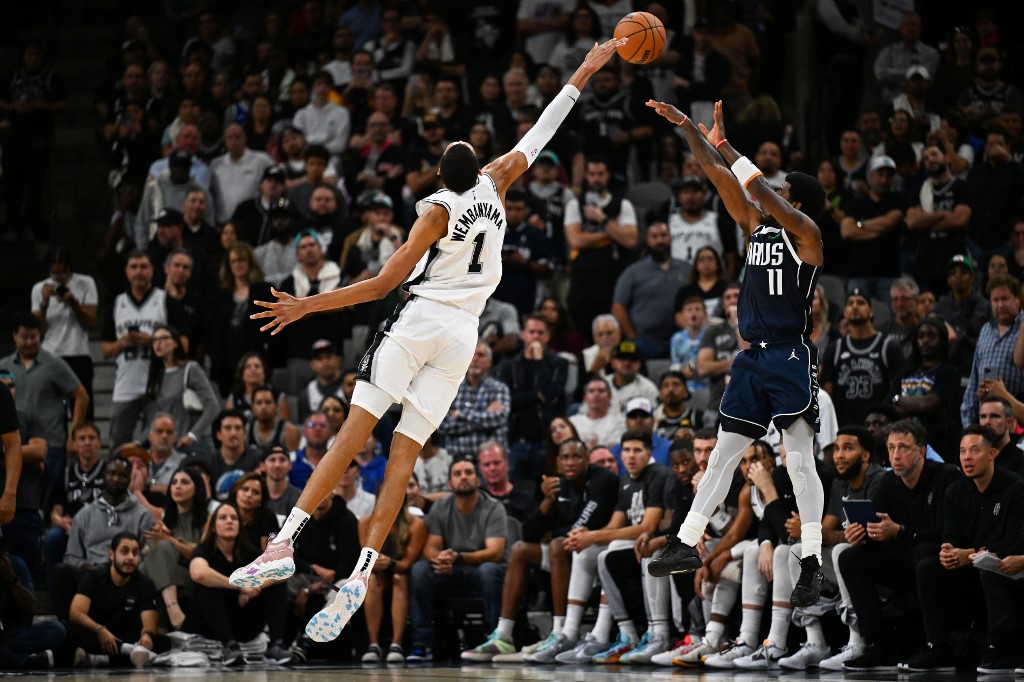 San Antonio Spurs center Victor Wembanyama jumps to block a shot by Dallas Mavericks guard Kyrie Irving. We're backing Wembanyama in our Nuggets vs. Spurs player props.
