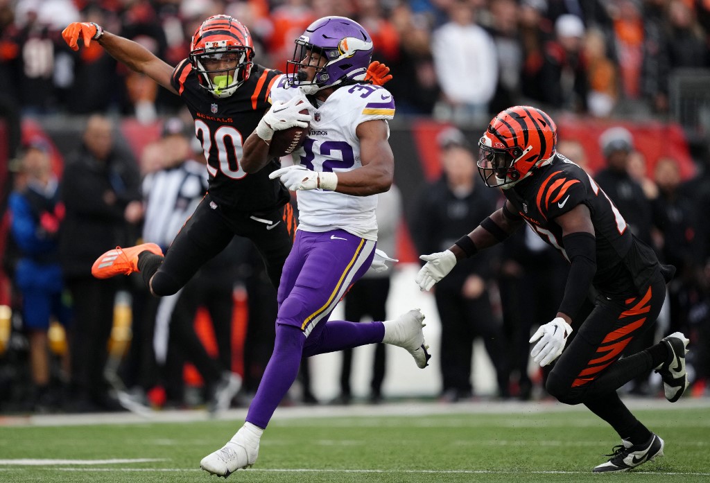 Ty Chandler of the Minnesota Vikings carries the ball ahead of our Sunday Night Football Week 17 NFL predictions for Packers vs. Vikings