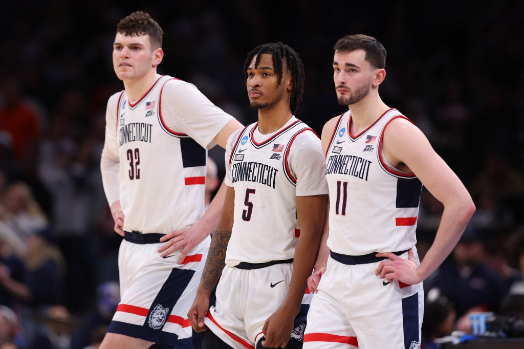 Donovan Clingan, Stephon Castle, and Alex Karaban of the UConn Huskies look on against the Illinois Fighting Illini during the Elite 8 round of the NCAA Men's Basketball Tournament. We're backing the Huskies defense in our Alabama vs. UConn prediction.