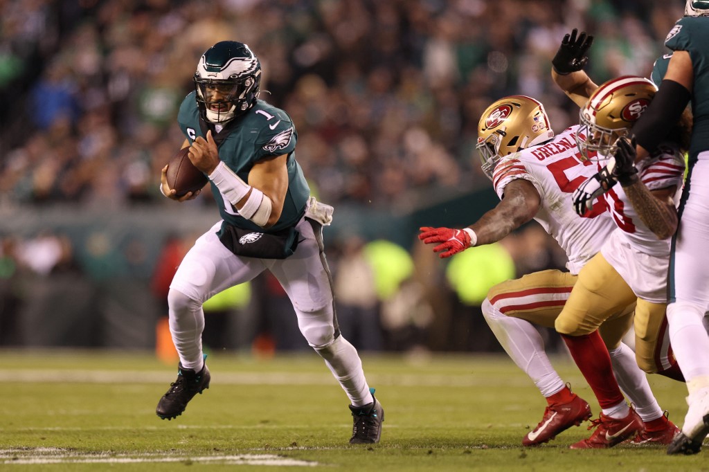 Jalen Hurts of the Philadelphia Eagles runs the ball as we share our best Jalen Hurts prop predictions for 49ers vs. Eagles.
