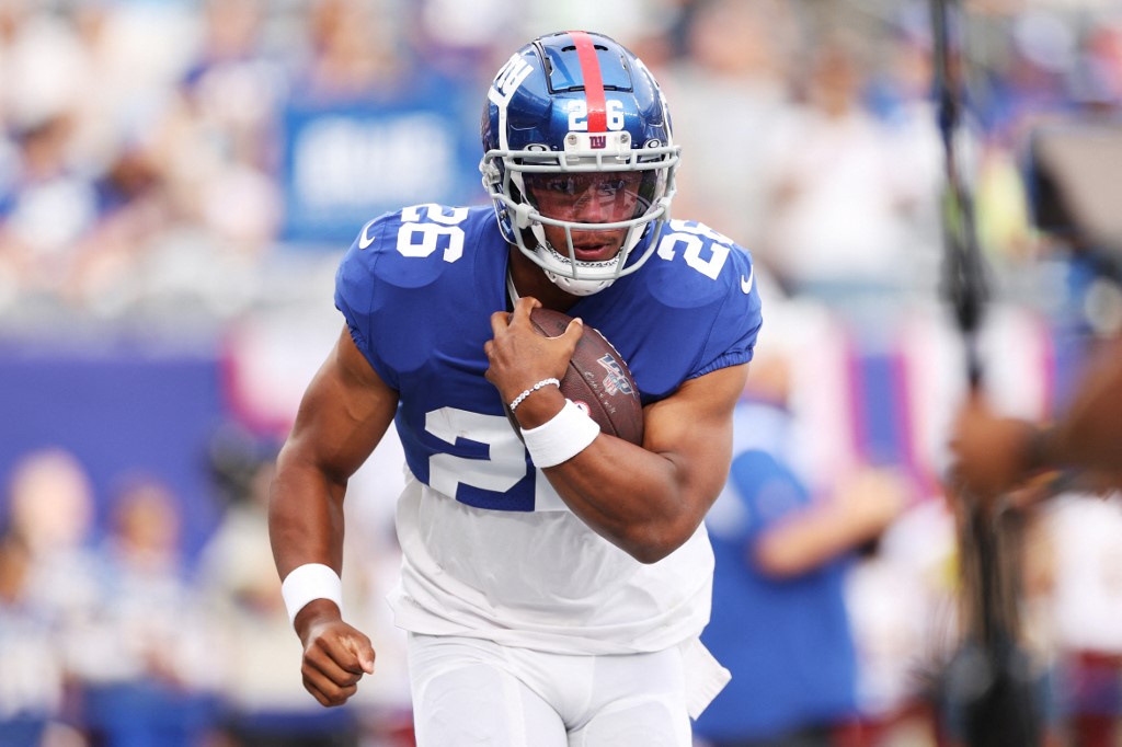 Saquon Barkley of the New York Giants carries the ball during warmups of a preseason game against the Cincinnati Bengals, and we offer our top rushing props predictions for Week 10 based on the best NFL odds.