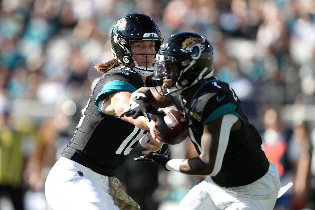 Trevor Lawrence #16 of the Jacksonville Jaguars hands the ball off to Travis Etienne Jr. #1 as we round up our NFL predictions for Week 13