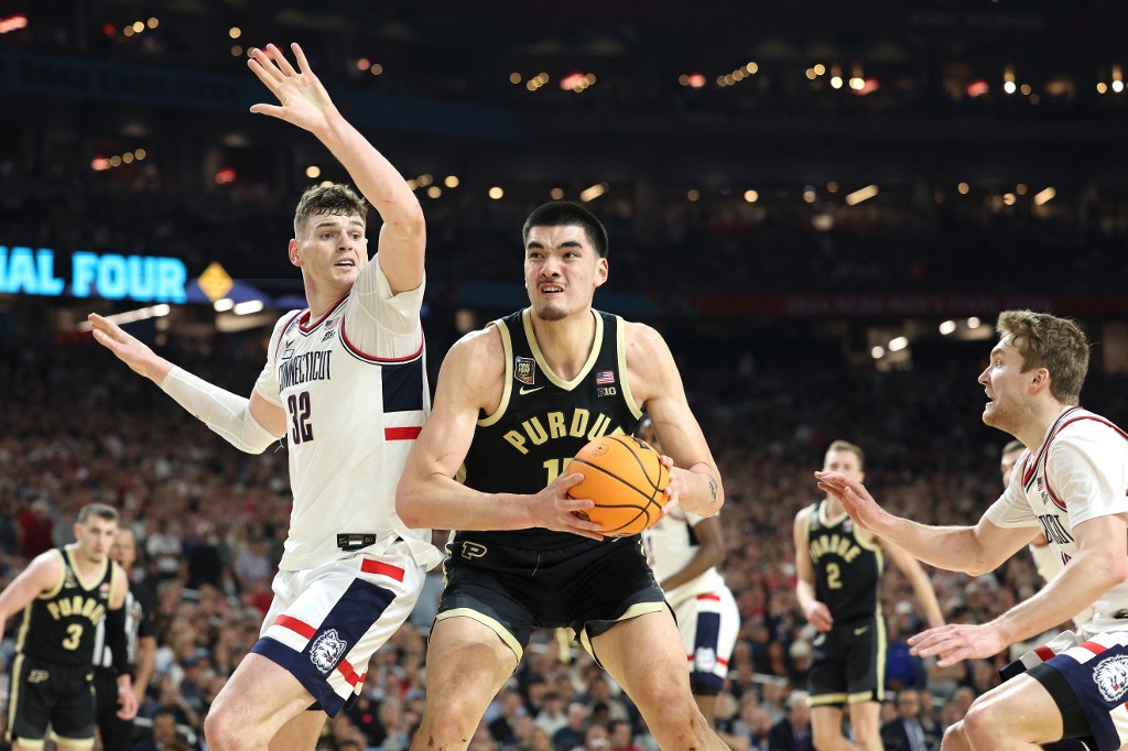 Zach Edey of the Purdue Boilermakers handles the ball while being guarded by Donovan Clingan of the UConn Huskies in the NCAA Men's Basketball Tournament National Championship game. Edey was the favorite by the 2024 Wooden Award odds all season.